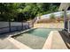 Backyard boasts a sparkling pool, bordered by lush greenery, fencing and a stone retaining wall at 998 Poplar Mill Ct, Buford, GA 30518