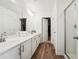 Bright bathroom with dual sinks, wood-look flooring, and glass-enclosed shower at 1001 Starmoss Ln, Conyers, GA 30094