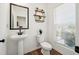 Clean and modern half bathroom with pedestal sink, toilet, and decorative shelves at 1001 Starmoss Ln, Conyers, GA 30094