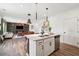 Open kitchen features white cabinets, stainless appliances, and an island with barstool seating at 1001 Starmoss Ln, Conyers, GA 30094