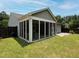 Back exterior featuring a screened porch attached to the home, grassy lawn, stone patio and a dark wood fence at 2871 Goldfinch Cir, Marietta, GA 30066
