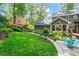 Spacious backyard features green grass, manicured garden beds, mature trees, and a beautiful patio at 4686 Buckskin Sw Trl, Lilburn, GA 30047