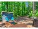 Landscaped backyard with blue storage building, two chairs, and brick patio at 4686 Buckskin Sw Trl, Lilburn, GA 30047