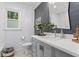 Bathroom features a gray vanity, modern hardware, and a window providing natural light at 4686 Buckskin Sw Trl, Lilburn, GA 30047