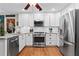 Bright kitchen with white cabinets, stainless steel appliances, and hardwood floors at 4686 Buckskin Sw Trl, Lilburn, GA 30047