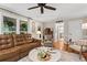 Spacious living room featuring hardwood floors, a comfortable leather sofa, and ample natural light at 4686 Buckskin Sw Trl, Lilburn, GA 30047