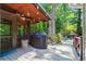 Outdoor patio featuring a grill, string lights, wood ceiling, and access to the beautifully landscaped yard at 4686 Buckskin Sw Trl, Lilburn, GA 30047