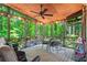 Inviting screened porch with wood ceiling, fan, and view of the backyard's trees at 4686 Buckskin Sw Trl, Lilburn, GA 30047