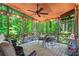 Relaxing screened porch features wood ceiling, ceiling fan, exterior string lights, and views of the wooded backyard at 4686 Buckskin Sw Trl, Lilburn, GA 30047
