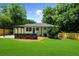 Large backyard with a well-manicured lawn, a cozy patio, and privacy fencing at 3388 Elgin Dr, Decatur, GA 30032