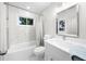 Nicely renovated bathroom features a modern vanity, tub with shower, and large mirror at 3388 Elgin Dr, Decatur, GA 30032