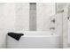 Bright bathroom featuring a soaking tub with elegant marble tile surround and contrasting gray accent tile at 3388 Elgin Dr, Decatur, GA 30032
