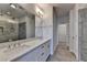 Bright bathroom featuring double vanity, large mirror, walk-in shower with gray tiles, and tile flooring at 3879 Glenview Club Ln, Duluth, GA 30097