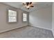 Bedroom with neutral walls, carpet, ceiling fan, and windows overlooking the neighborhood at 3879 Glenview Club Ln, Duluth, GA 30097