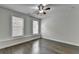 Large bedroom boasts hardwood floors, ceiling fan, and multiple windows for natural light at 3879 Glenview Club Ln, Duluth, GA 30097