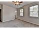 Spacious bedroom featuring neutral walls, two windows, carpeted floor, and a ceiling fan at 3879 Glenview Club Ln, Duluth, GA 30097