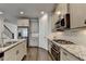 Modern kitchen featuring stainless appliances, granite counters, hardwood floors, and a staircase at 3879 Glenview Club Ln, Duluth, GA 30097