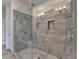 Walk-in shower with gray stone-look tiles, rainfall shower head, and a built-in niche for toiletries at 3879 Glenview Club Ln, Duluth, GA 30097