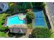 Aerial shot of a community pool, hot tub, and tennis court with lush green landscaping and surrounding residential area at 6520 Fairfield Trce, Suwanee, GA 30024
