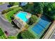 An aerial view featuring a community pool, clubhouse, tennis court, and lush landscaping at 6520 Fairfield Trce, Suwanee, GA 30024