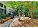 Picturesque backyard area with a stone patio, outdoor seating, and surrounding trees providing a serene outdoor retreat at 6520 Fairfield Trce, Suwanee, GA 30024