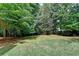 Lush backyard featuring a lawn, mature trees, and green foliage offering a peaceful outdoor space at 6520 Fairfield Trce, Suwanee, GA 30024