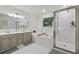 Large white bathroom featuring a double sink vanity, soaking tub, and a shower with glass doors at 6520 Fairfield Trce, Suwanee, GA 30024