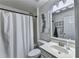 Clean bathroom with a white vanity, framed mirror, and a shower/tub combo with white shower curtain at 6520 Fairfield Trce, Suwanee, GA 30024