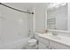 Bright bathroom features tub shower with white tiled walls, decorative wall art, and single sink at 6520 Fairfield Trce, Suwanee, GA 30024