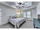 Bright bedroom featuring a tray ceiling, ceiling fan, plush carpet, and natural light from the window at 6520 Fairfield Trce, Suwanee, GA 30024