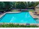 Beautiful community pool and hot tub area with lounge chairs, mature trees, and manicured landscaping for relaxation at 6520 Fairfield Trce, Suwanee, GA 30024