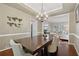 Elegant dining room features a chandelier, hardwood floors, and a view into the living room at 6520 Fairfield Trce, Suwanee, GA 30024