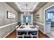 Formal dining room offers a modern chandelier, seating for six, and natural light at 6520 Fairfield Trce, Suwanee, GA 30024