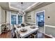 Formal dining room with hardwood floors, large windows, elegant chandelier and views to kitchen at 6520 Fairfield Trce, Suwanee, GA 30024