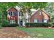 Charming two-story home featuring a brick facade, blue shutters, and a well-manicured front lawn at 6520 Fairfield Trce, Suwanee, GA 30024