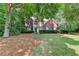 Beautiful two-story home with a manicured lawn, brick accents, and mature trees providing shade and privacy at 6520 Fairfield Trce, Suwanee, GA 30024