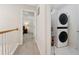 Upstairs hallway with a laundry closet containing a stacked washer and dryer at 6520 Fairfield Trce, Suwanee, GA 30024