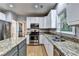 Bright kitchen with stainless steel appliances, granite countertops, and white cabinets at 6520 Fairfield Trce, Suwanee, GA 30024