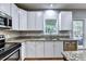 The eat-in kitchen features stainless steel appliances, granite counters and white cabinetry at 6520 Fairfield Trce, Suwanee, GA 30024