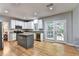 Open kitchen with a center island, stainless steel appliances, granite counters and a view to the backyard at 6520 Fairfield Trce, Suwanee, GA 30024