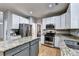 Bright kitchen with stainless steel appliances, granite countertops, white cabinets, and a center island at 6520 Fairfield Trce, Suwanee, GA 30024