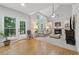 Bright living room with tall windows, a fireplace, built-in bookshelves, and hardwood floors at 6520 Fairfield Trce, Suwanee, GA 30024