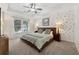 Spacious bedroom with tray ceiling, a window view, and decorative wallpaper at 6520 Fairfield Trce, Suwanee, GA 30024