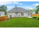 Large backyard with lush green grass, a patio, and a wooden fence for privacy at 1890 Owens Trl, Rex, GA 30273