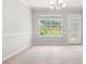Bright dining room features neutral decor, carpet, a window, and direct access to the backyard at 1890 Owens Trl, Rex, GA 30273
