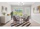 Bright dining room featuring modern furnishings, a chandelier, and a large window with a view of the backyard at 1890 Owens Trl, Rex, GA 30273