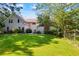 Spacious backyard featuring lush lawn and mature trees, providing a serene outdoor space with partial view of the home at 1961 Luke Edwards Rd, Dacula, GA 30019