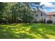 Expansive backyard with lush green lawn, mature trees, and partial view of the home's exterior, offers privacy at 1961 Luke Edwards Rd, Dacula, GA 30019