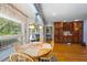 Sunlit dining room featuring hardwood floors, large windows, and built-in cherry wood cabinetry with wine rack at 1961 Luke Edwards Rd, Dacula, GA 30019