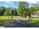 View of the long driveway lined with manicured lawn, leading to a stately home surrounded by mature trees at 1961 Luke Edwards Rd, Dacula, GA 30019